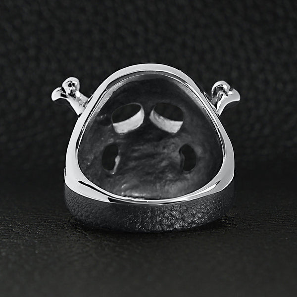 Stainless steel skull and crossbones ring back view on a black leather background.