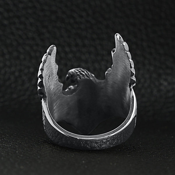 Stainless steel flying eagle ring back view on a black leather background.