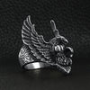 Stainless steel flying eagle ring angled on a black leather background.