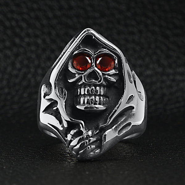 Stainless steel red Cubic Zirconia eyed grim reaper ring on a black leather background.