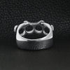 Stainless steel polished knuckle duster ring back view on a black leather background.