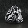Stainless steel nude woman Goddess ring angled on a black leather background.