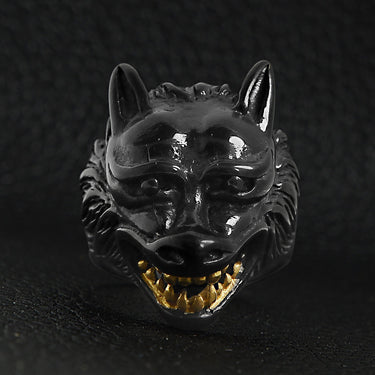 Stainless steel black wolf with 18K gold PVD Coated teeth ring on a black leather background.