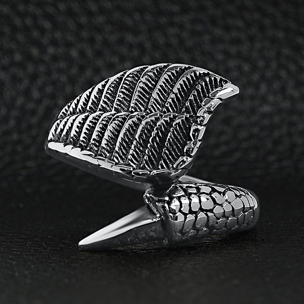 Stainless steel dragon claw and angel wing ring on a black leather background.