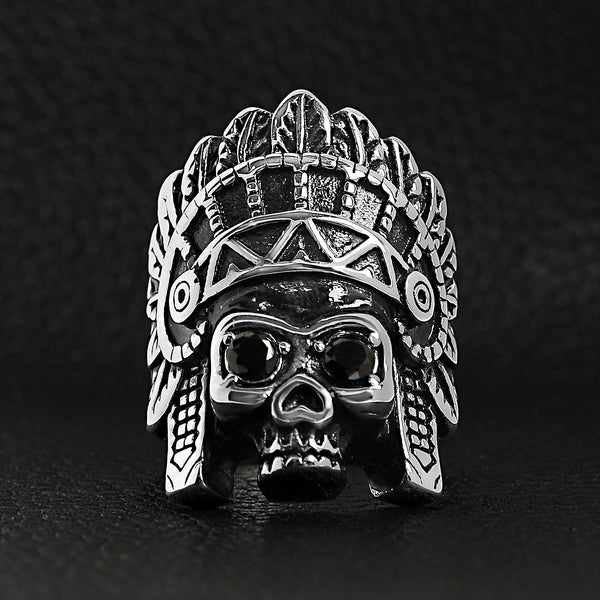 Stainless steel black Cubic Zirconia eyed Native American chief skull ring on a black leather background.