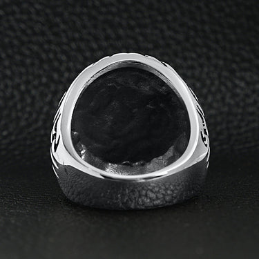 Stainless steel large filigree skull signet ring back view on a black leather background.