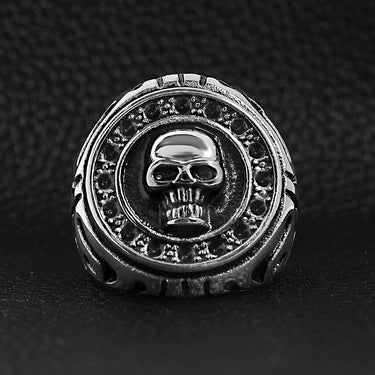 Stainless steel large filigree skull signet ring on a black leather background.
