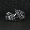 Stainless steel angel wings ring on a black leather background.