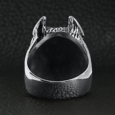 Stainless steel pit bull dog ring back view on a black leather background.