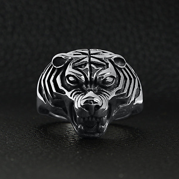 Stainless steel snarling tiger ring on a black leather background.