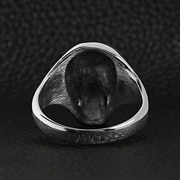 Stainless steel skull women's ring back view on a black leather background.