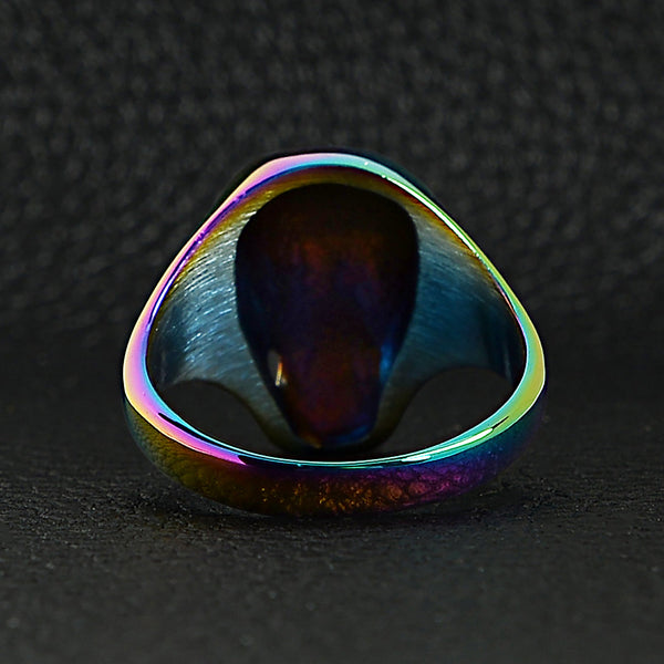 Stainless steel rainbow skull ring back view on a black leather background.