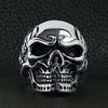 Stainless steel skull with skeleton accents ring on a black leather background.