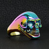 Stainless steel rainbow skull ring angled on a black leather background.
