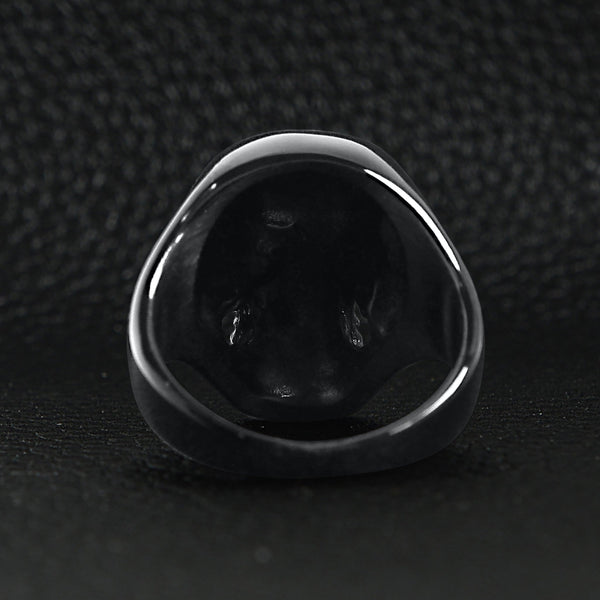 Stainless steel clear Cubic Zirconia eyed black skull ring back view on a black leather background.