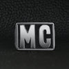 Stainless steel motorcycle club "MC" insignia signet ring on a black leather background.