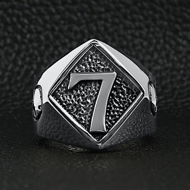 Stainless steel lucky "7" with skull accents signet ring on a black leather background.