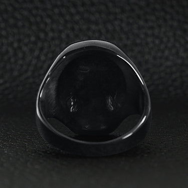 Stainless steel red Cubic Zirconia eyed black skull ring back view on a black leather background.