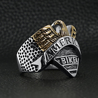 Stainless steel "AMERICAN BIKER" with 18K gold PVD Coated eagle ring angled on a black leather background.