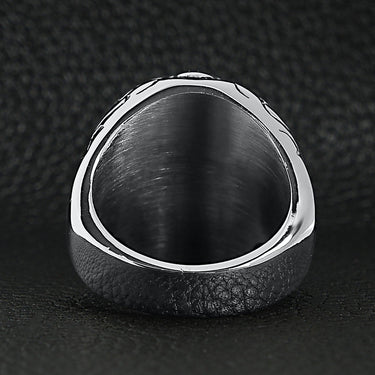 Stainless steel red Cubic Zirconia eyed sugar skull ring back view on a black leather background.