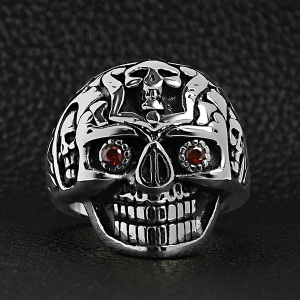 Stainless steel red Cubic Zirconia eyed sugar skull ring on a black leather background.