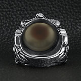 Stainless steel gothic red eyeball with claw and skull accents ring back view on a black leather background.