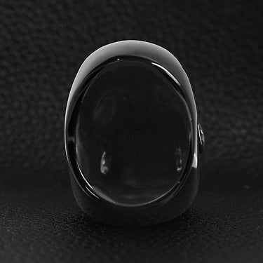 Stainless steel black skull ring back view on a black leather background.