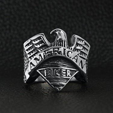 Stainless steel "AMERICAN BIKER" with eagle ring on a black leather background.