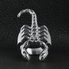 Stainless steel scorpion men's ring on a black leather background.