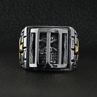 Stainless steel medieval jailed skull with 18K gold PVD Coated Cross accents ring on a black leather background.