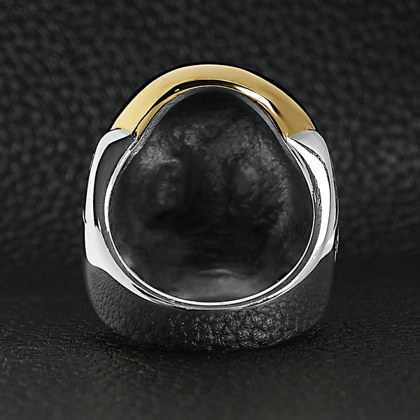 Stainless steel and 18K gold PVD Coated skull ring back view on a black leather background.