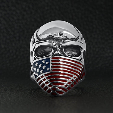 Stainless steel USA American flag covered skull ring on a black leather background.