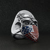 Stainless steel USA American flag covered skull ring angled on a black leather background.