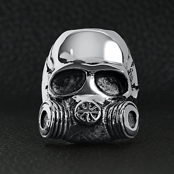 Stainless steel gas mask skull ring on a black leather background.