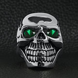 Stainless steel green Cubic Zirconia eyed cracked skull ring on a black leather background.