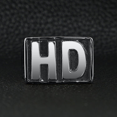 Stainless steel heavy duty "HD" signet ring on a black leather background.