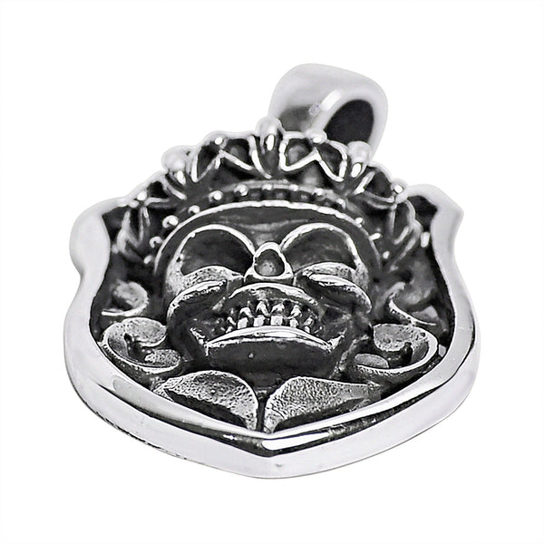 Sterling silver skull shield pendant at an angle.