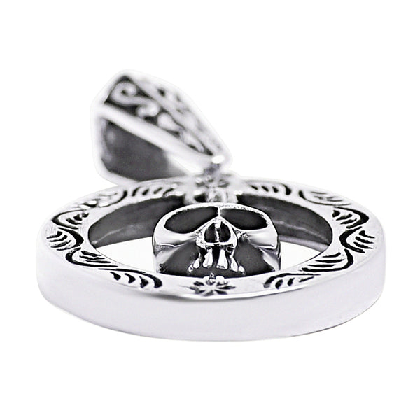 Sterling silver circle skull pendant at an angle.
