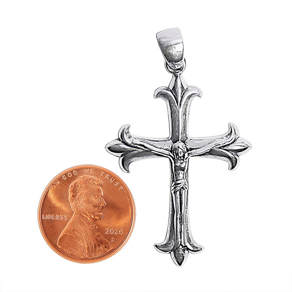 Sterling silver crucifix cross pendant with a penny for scale.