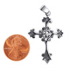 Sterling silver detailed cross pendant with a penny for scale.