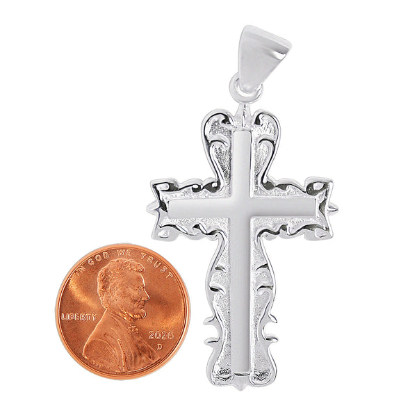 Sterling silver detailed cross pendant with a penny for scale.