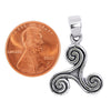Sterling silver Celtic Triskelion or Triple Spiral pendant with a penny for scale.