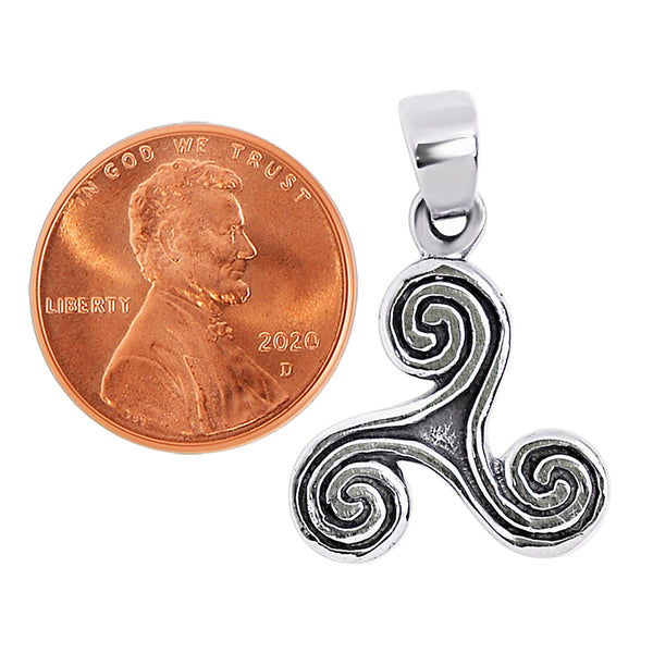Sterling silver Celtic Triskelion or Triple Spiral pendant with a penny for scale.