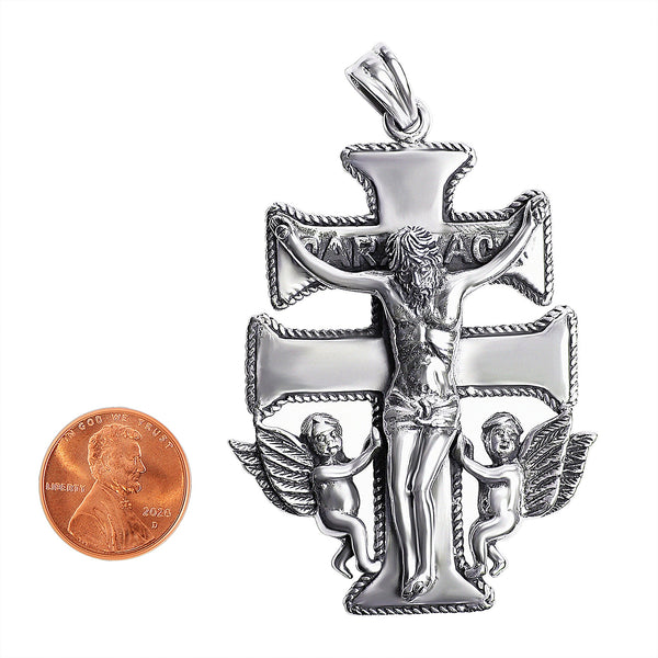 Sterling silver Caravaca Crucifix Cross pendant with a penny for scale.