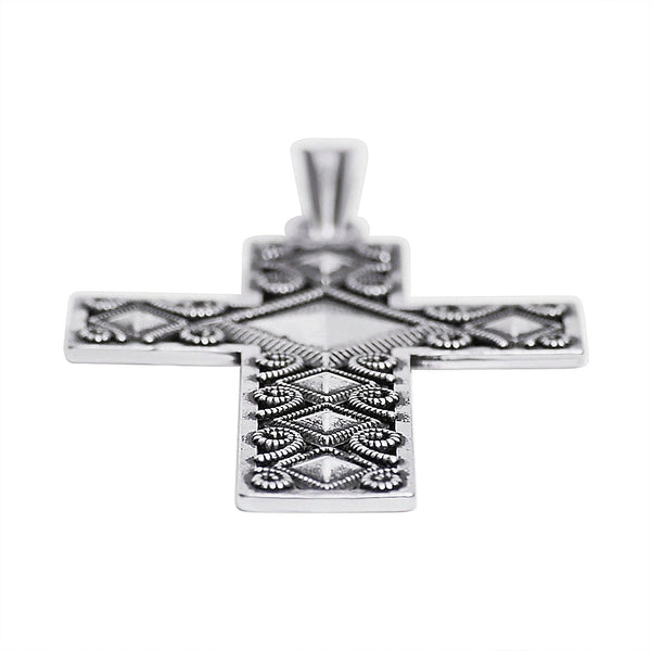 Sterling silver diamond shape filigree Cross pendant at an angle.