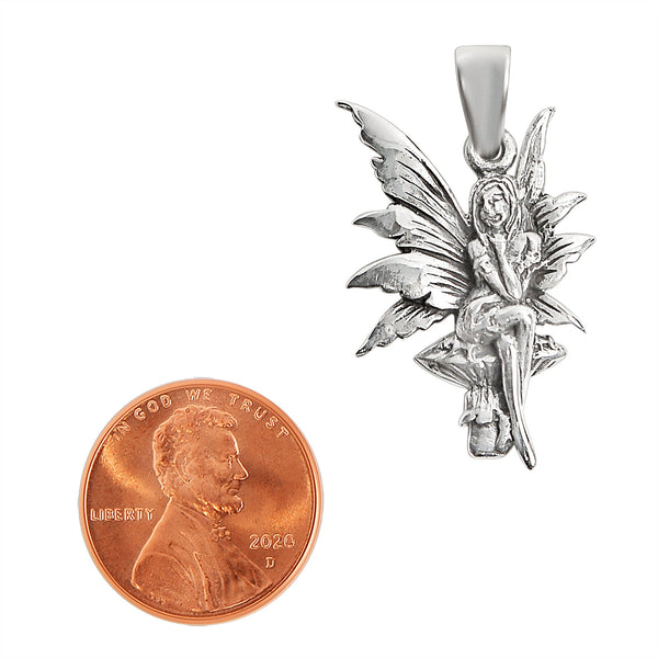 Sterling silver fairy on mushroom pendant with a penny for scale.
