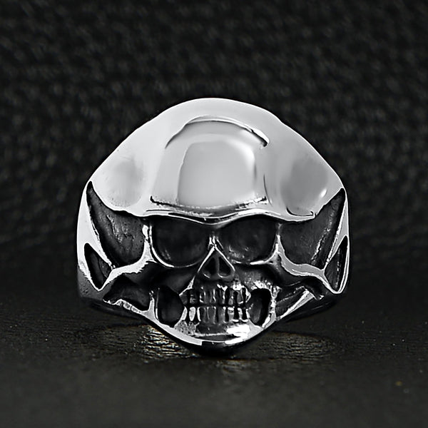 Sterling silver black eyed skull ring on a black leather background.