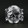 Sterling silver pirate skull ring on a black leather background.