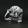 Sterling silver pirate skull ring angled on a black leather background.