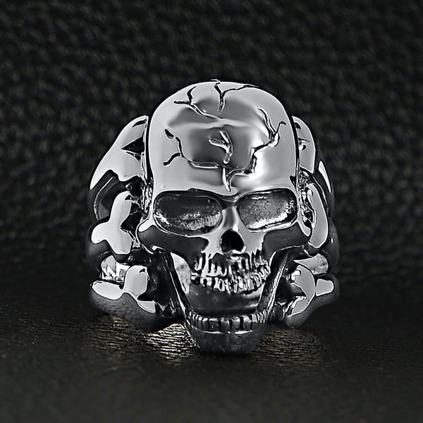 Sterling silver screaming cracked skull with bones ring on a black leather background.
